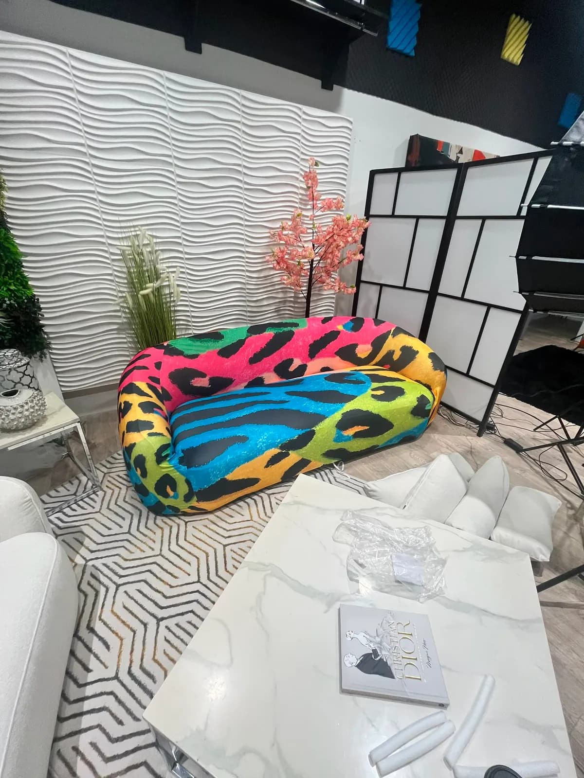 The rainbow leopard-print sofa beside the shoji screen