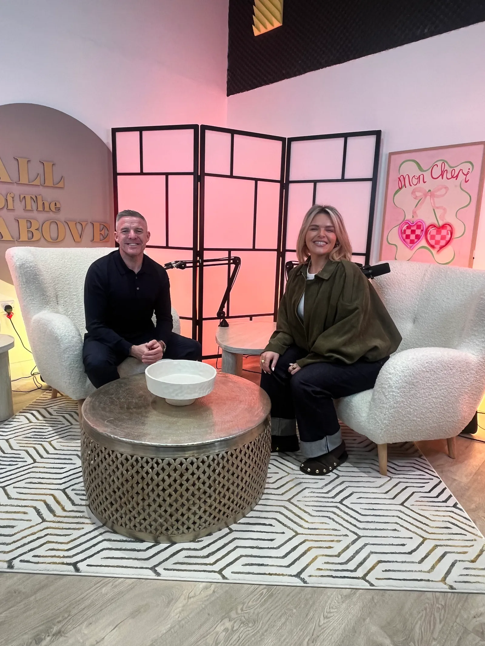 Two guests recording a podcast on the pink set at Magic Door Studio