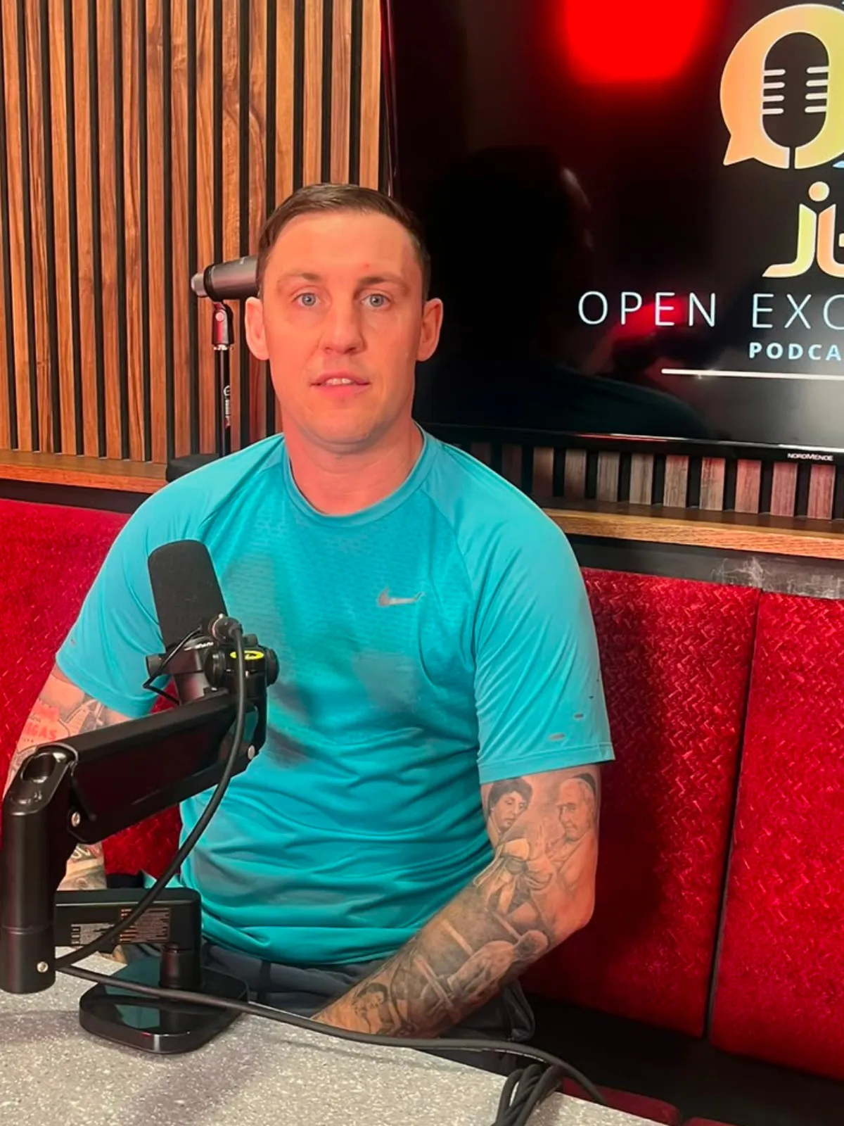 The Open Exchange host in front of the show's logo at Magic Door Studio