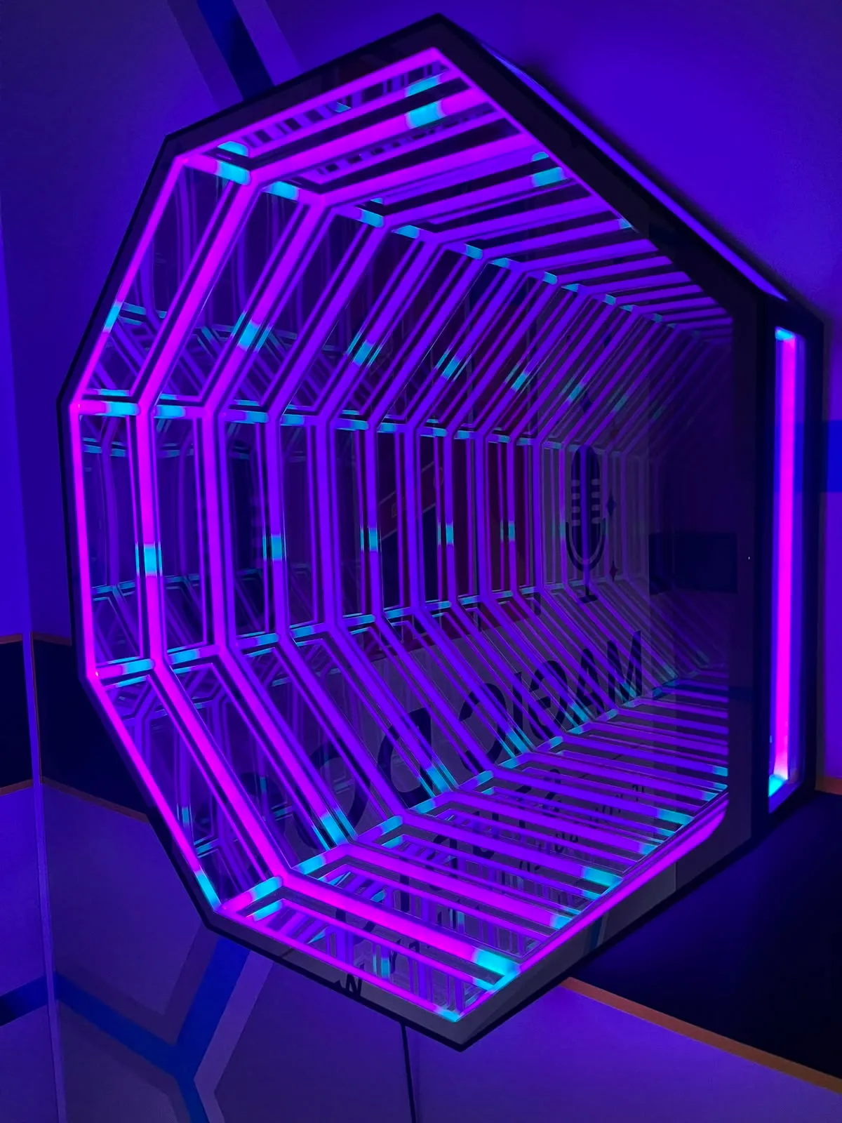 The octagon infinity mirror glowing violet on the hexagon wall