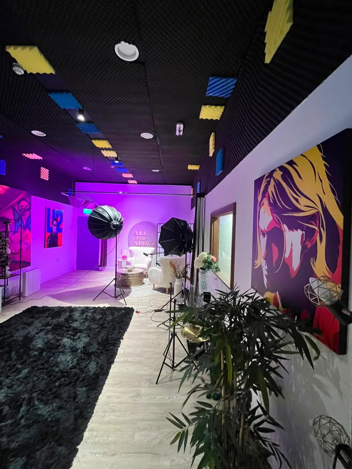 Studio 2 under a violet wash: softboxes aimed at the All Of The Above set, pop art on the walls