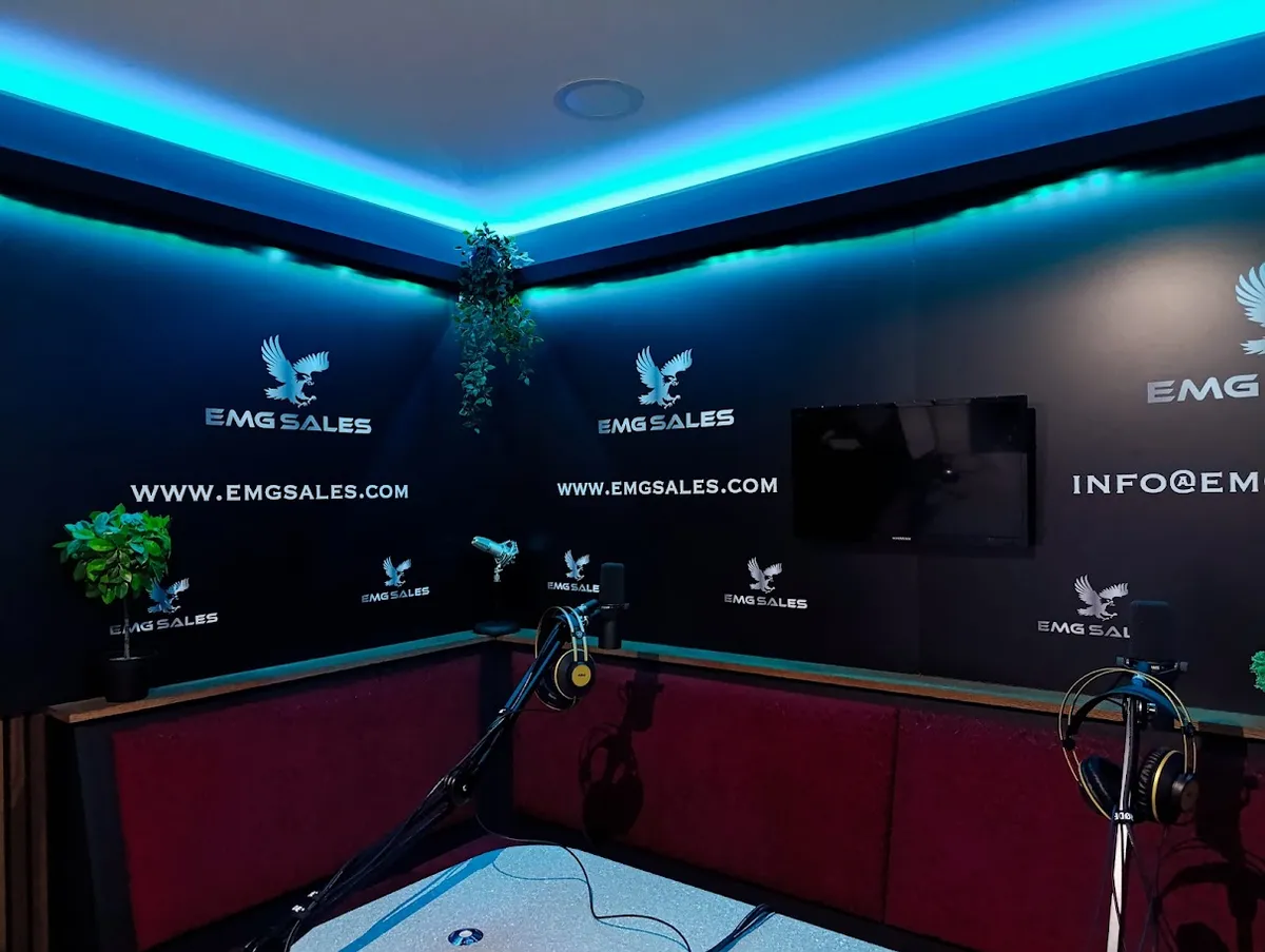 EMG Sales: the booth wrapped wall to wall in their branding under teal light