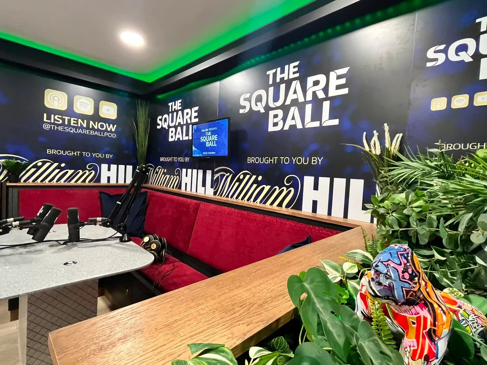 The Square Ball set under green light, the graffiti bulldog keeping watch from the plants