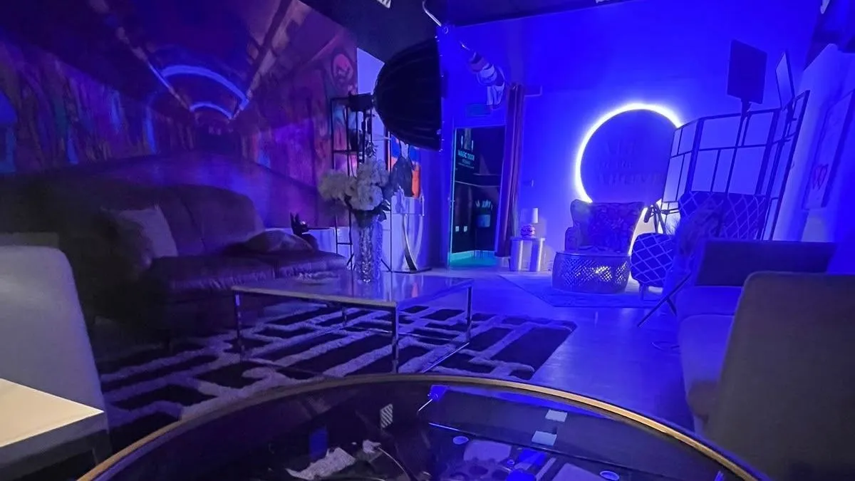 Studio 2 after dark: the gear-wheel clock table, leather sofa and the glowing halo sign